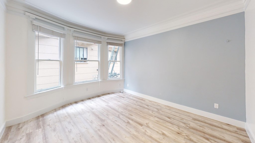 an empty living room with wood floors and windows