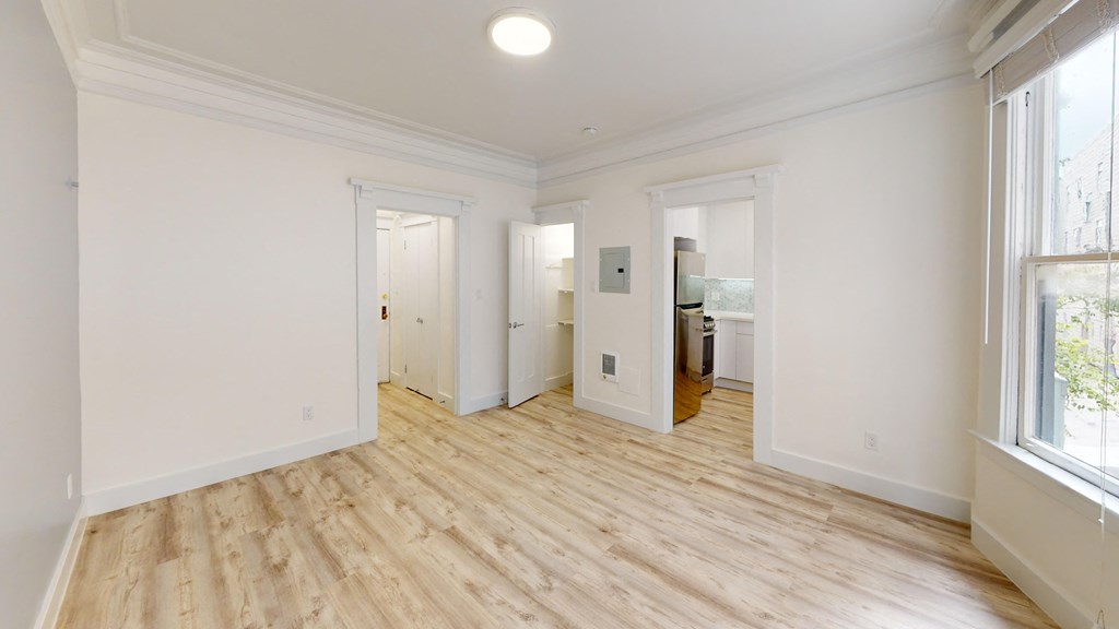 a living room with white walls and wood floors