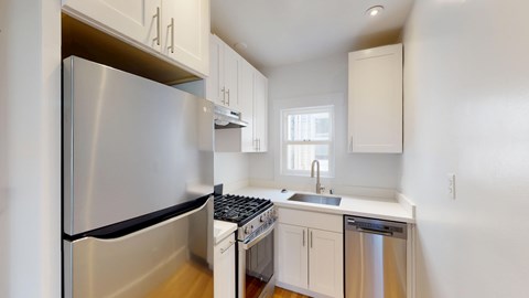 A modern kitchen with stainless steel appliances and white cabinets.
