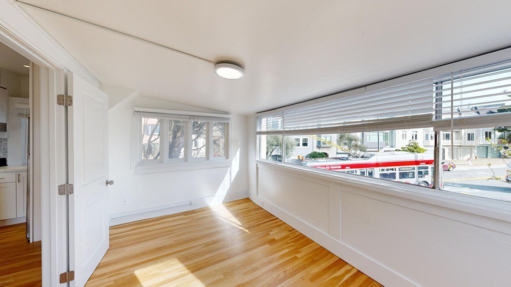 a living room with a large window and wooden floors
