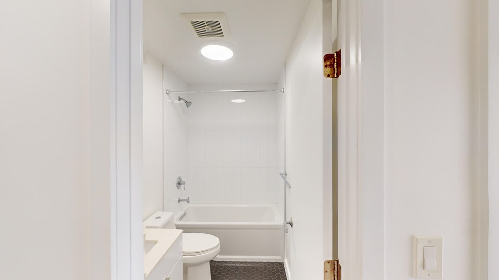 A white bathroom with a toilet, sink, and bathtub.
