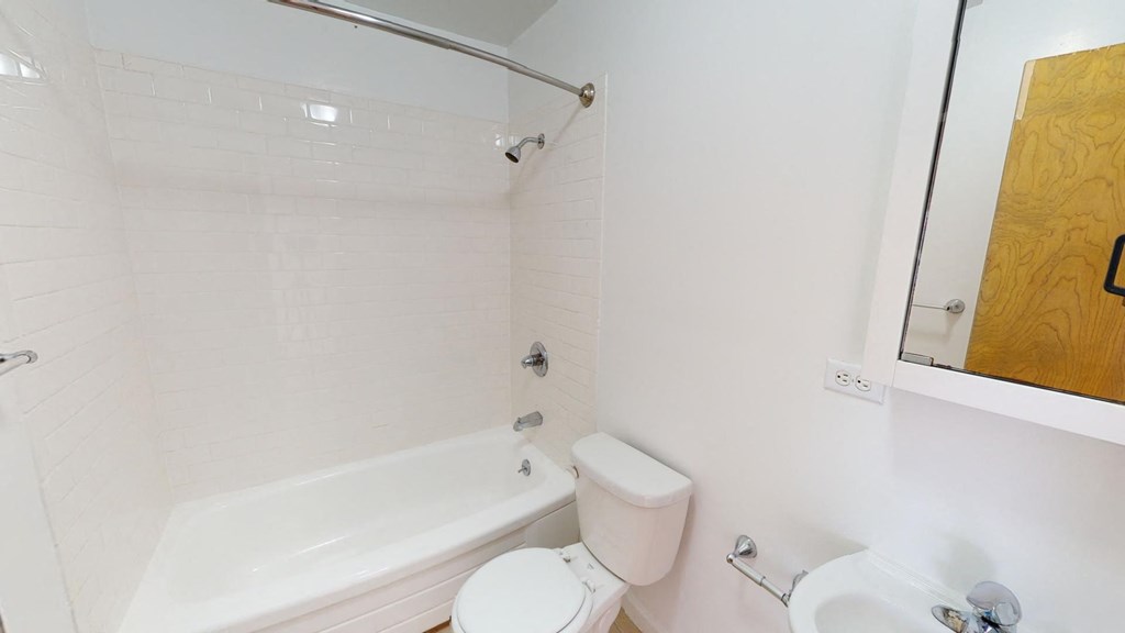 a bathroom with a toilet and a tub and a sink