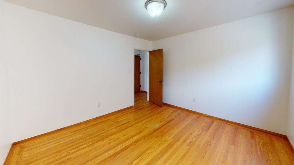 a empty room with wood floors and white walls