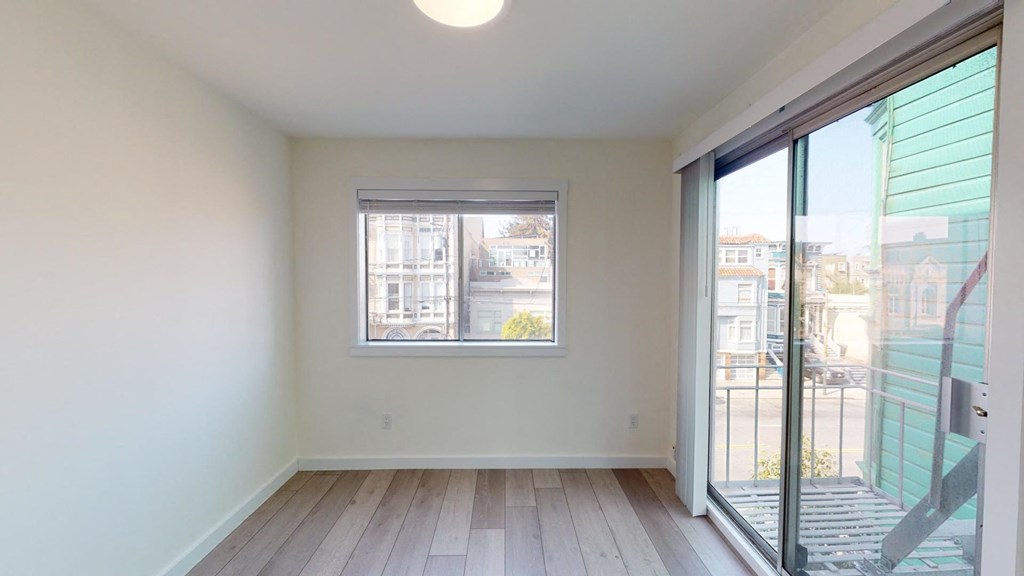 a living room with a large window and a door to a balcony