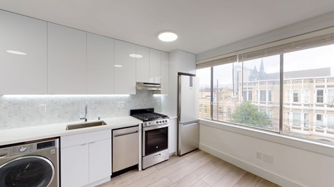 A modern kitchen with stainless steel appliances and white cabinets.