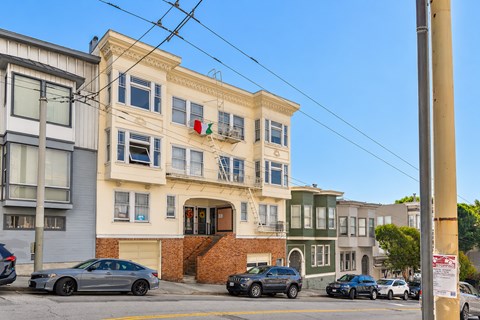 A street view of a building with a car parked in front.