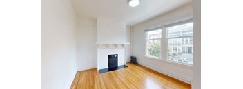 an empty living room with a fireplace and a large window