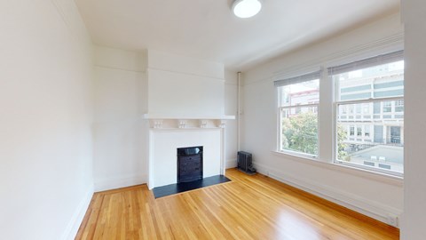an empty living room with a fireplace and a large window