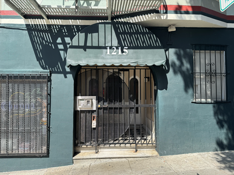 A blue building with a white awning and the number 1215 on it.