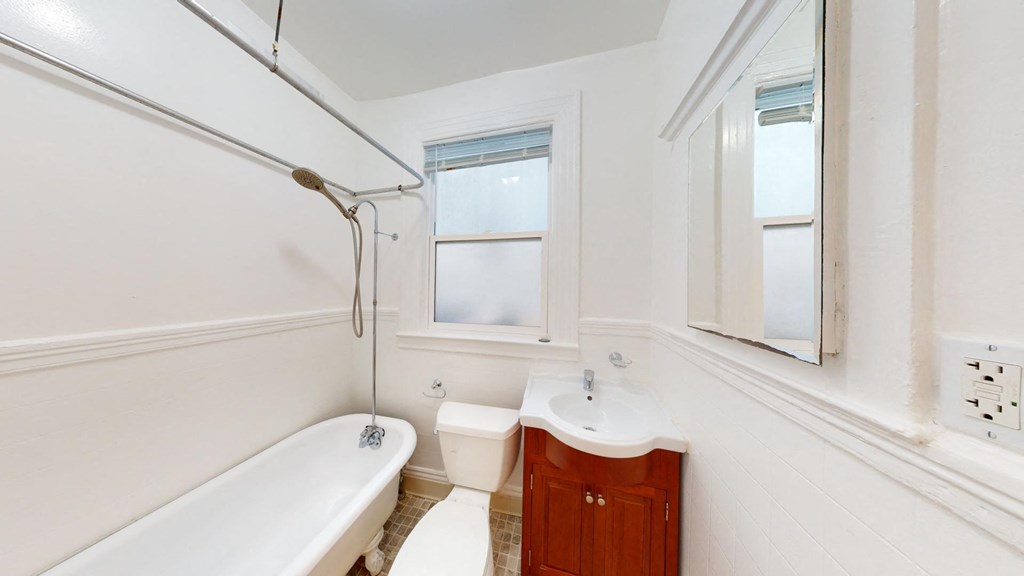 a bathroom with a tub and a sink and a window