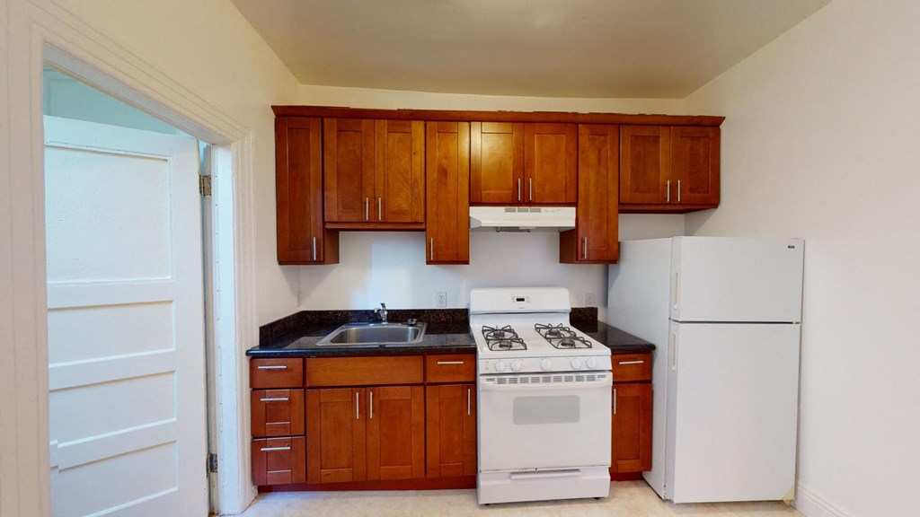 a kitchen with white appliances and wooden cabinets