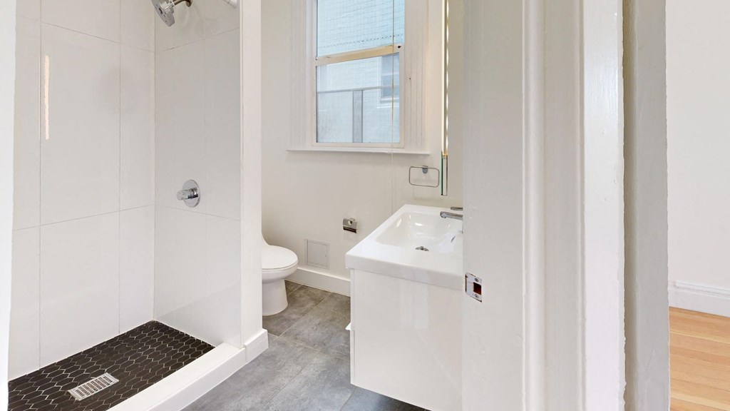 a white bathroom with a toilet and a sink
