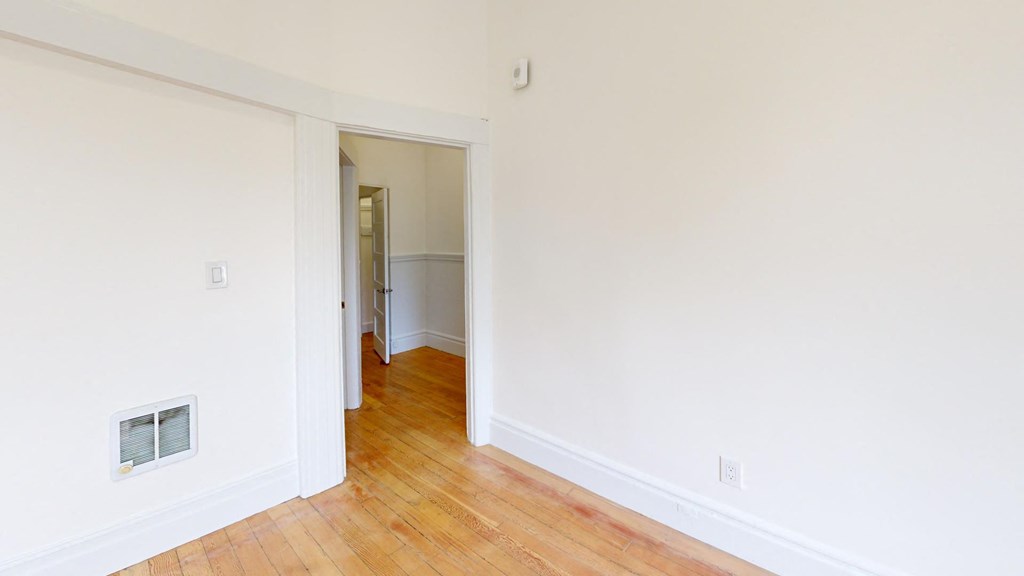 a room with a hard wood floor and white walls