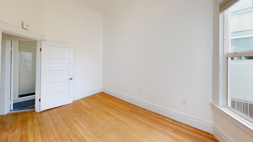 a living room with a wooden floor and a white door