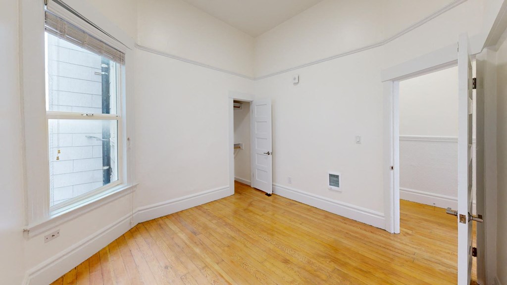 an empty room with white walls and a wooden floor