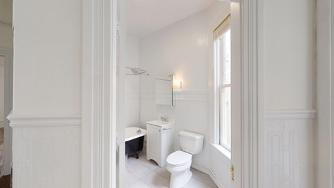 A white bathroom with a toilet, sink, and shower.