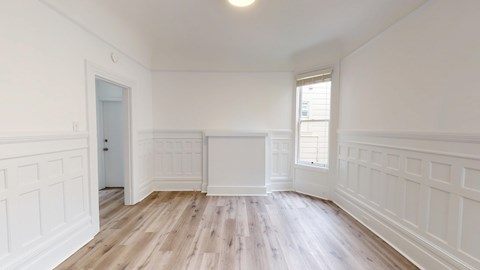 A room with white walls and wooden flooring.