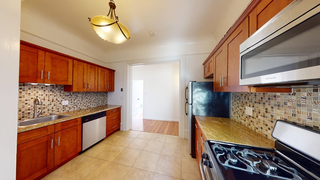 Kitchen with multiple cabinets, refrigerator, stove, and sink