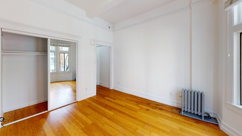 A room with wooden floors and a white wall.