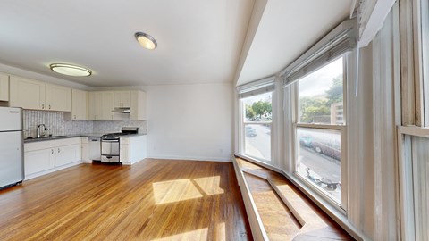 A kitchen with wooden floors and white cabinets.