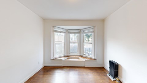 A room with a window and a radiator on the wall.