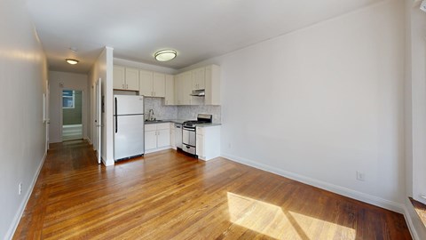 A kitchen with white cabinets and a refrigerator.