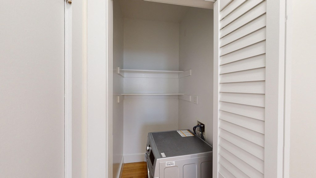 an empty closet with a washer and dryer in it