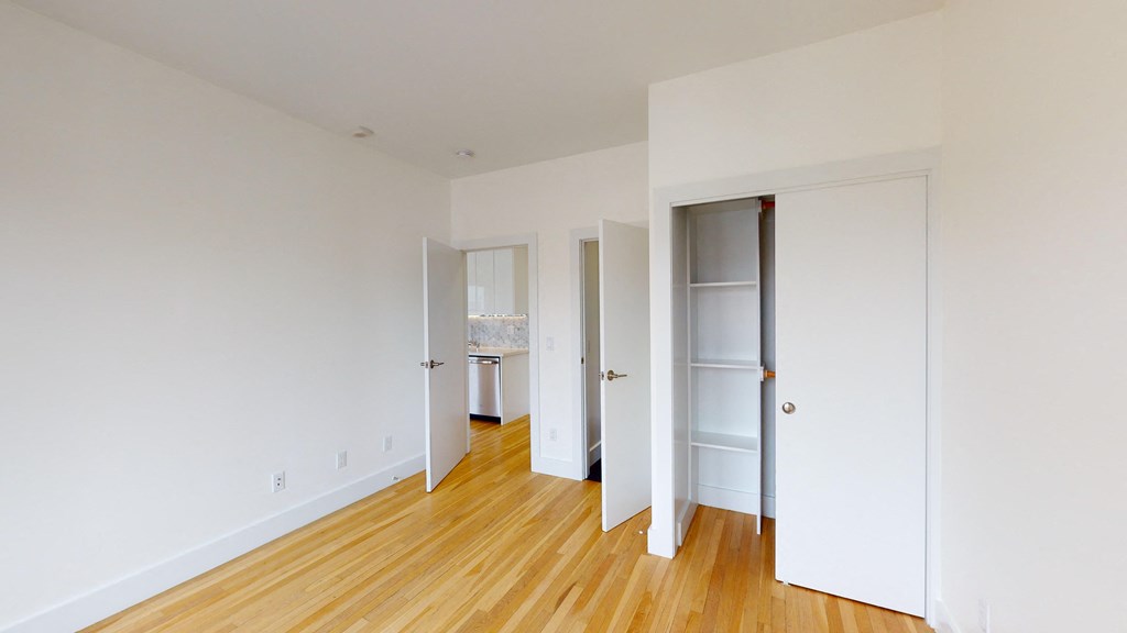 a living room with white walls and wooden floors and white doors