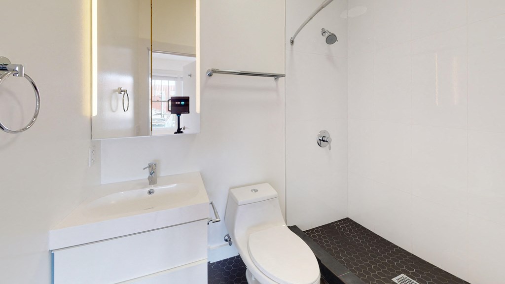 a white bathroom with a white toilet and a sink