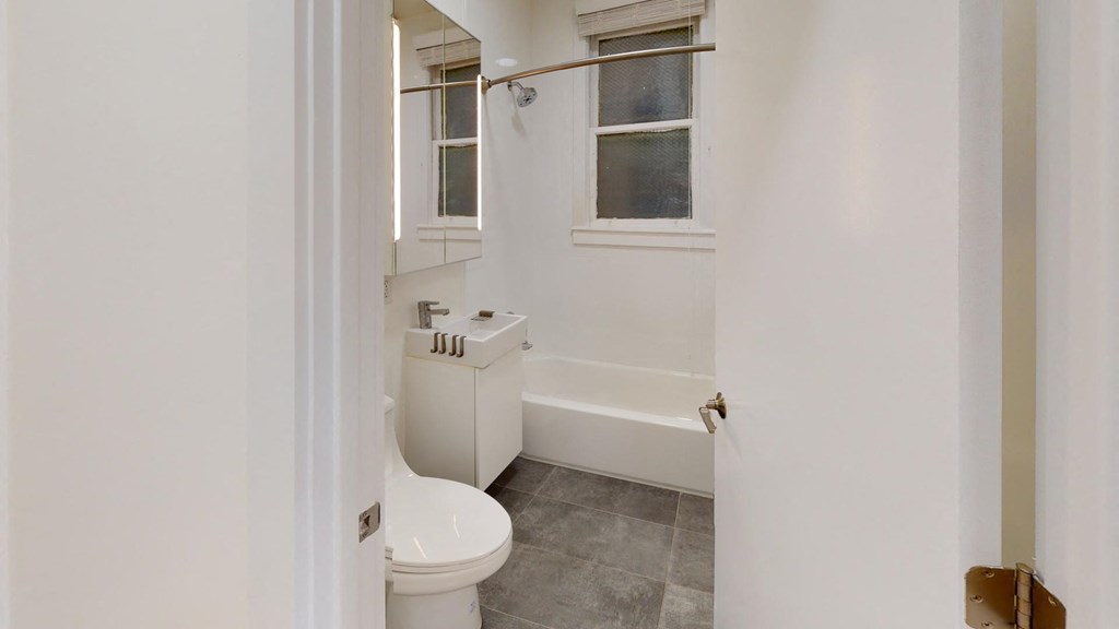 a bathroom with a toilet and a tub and a window