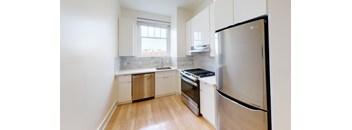 a kitchen with stainless steel appliances and white cabinets