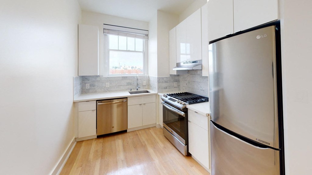 a kitchen with stainless steel appliances and white cabinets