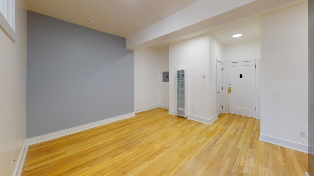 a renovated living room with wood floors and white walls