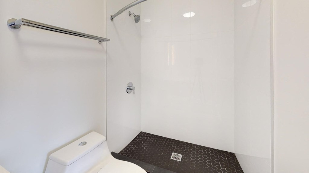 a white bathroom with a shower and a toilet