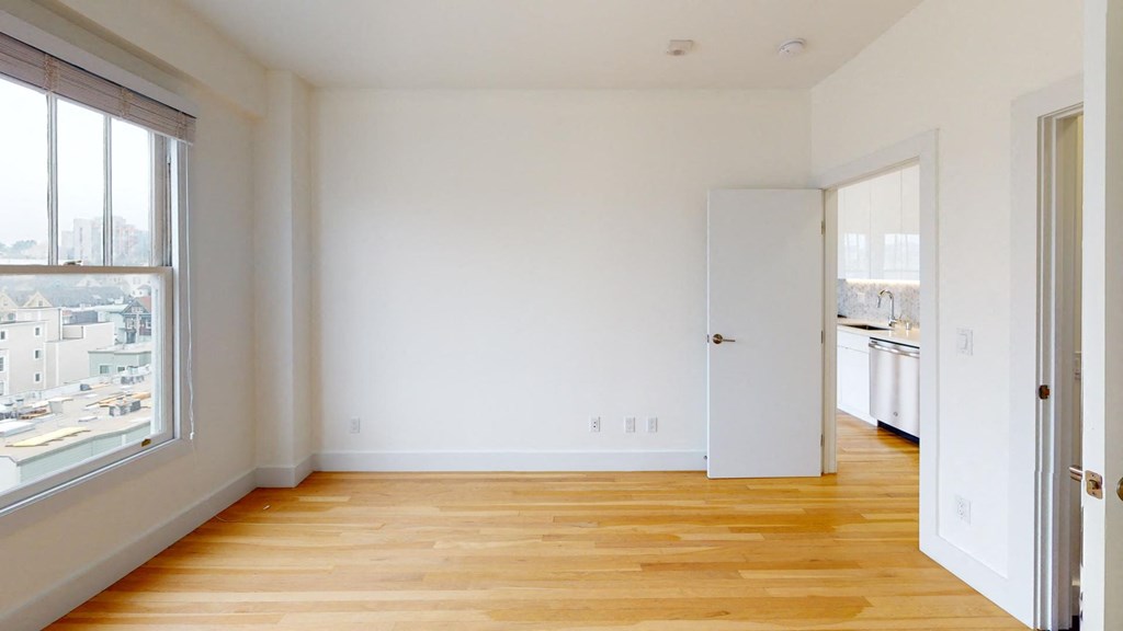a living room with a hard wood floor and a large window