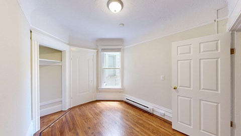 A room with a wooden floor and white walls.