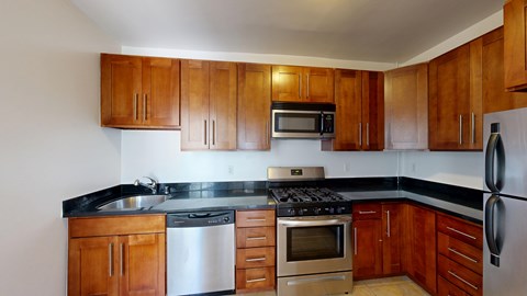 A kitchen with wooden cabinets and stainless steel appliances.