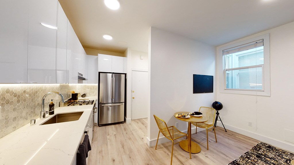 a kitchen with white cabinets and a counter top and a sink