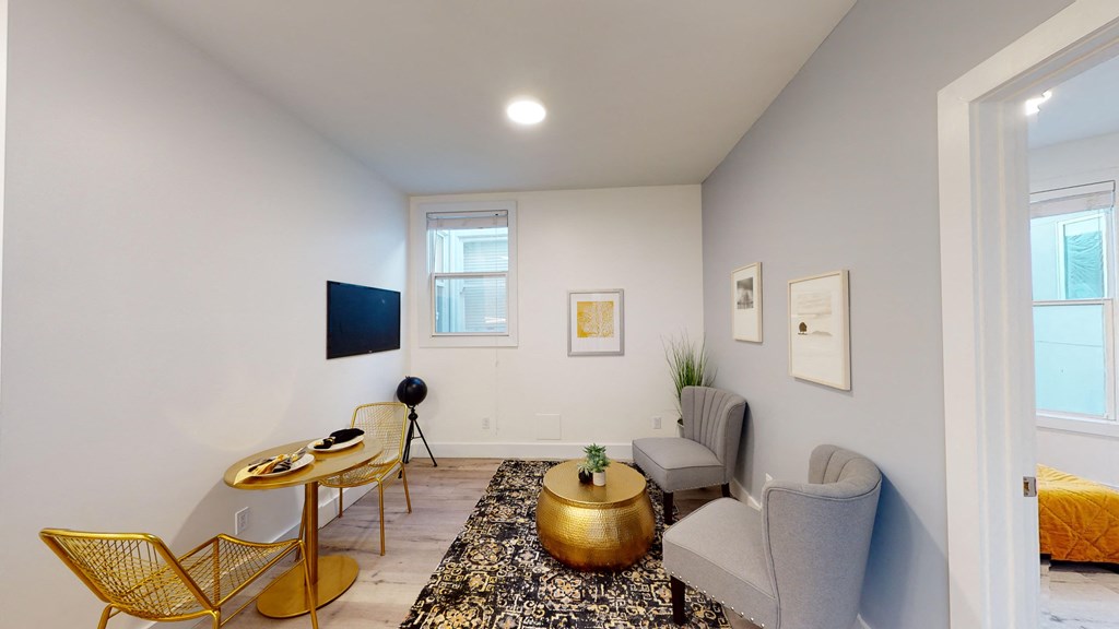 a living room with two chairs and a table and a tv