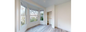an empty room with white walls and large windows and a closet