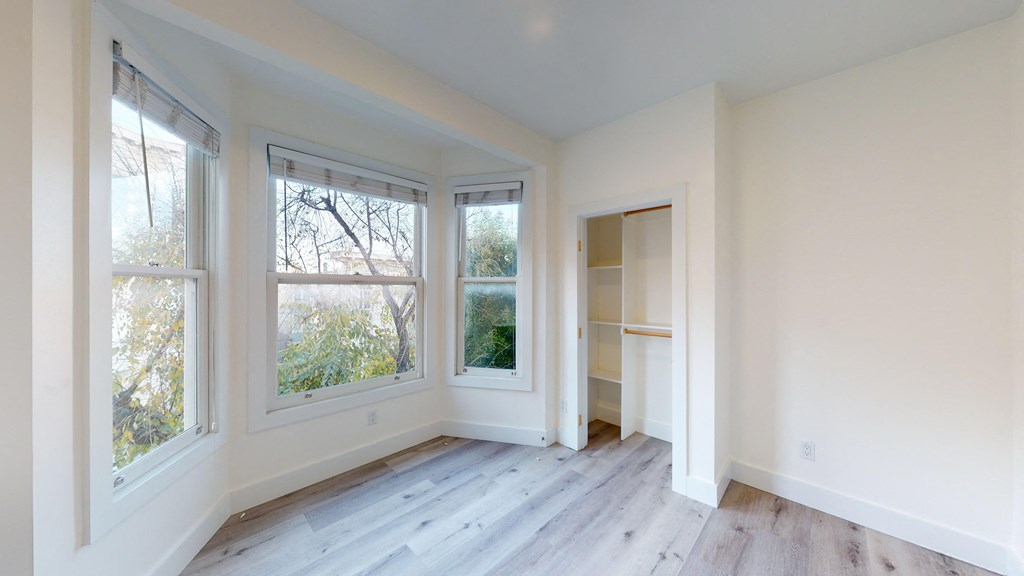 an empty room with white walls and large windows and a closet