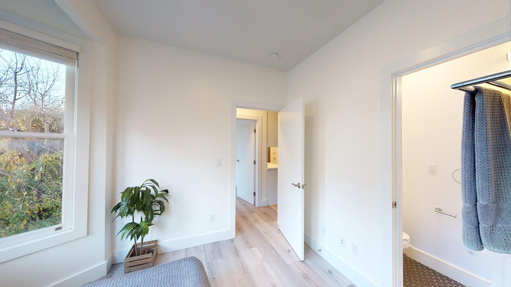 a living room with white walls and a large window