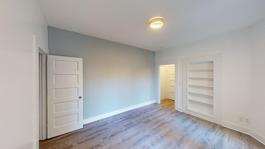a living room with white doors and a wood floor