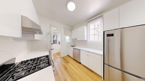 A kitchen with white cabinets and a black stove top oven.