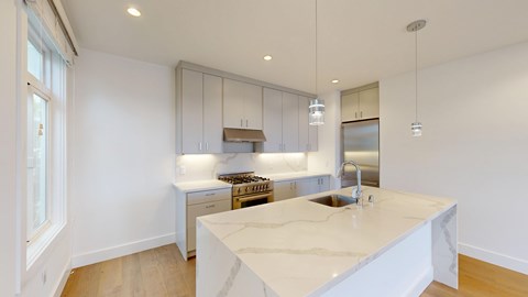 A kitchen with a marble countertop and stainless steel appliances.