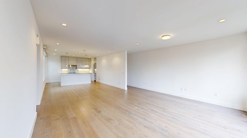 A large empty room with wooden floors and white walls.