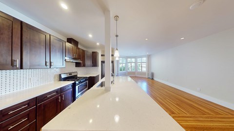 A modern kitchen with dark wood cabinets and a white countertop.