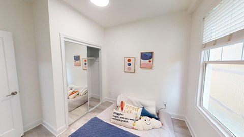 A bedroom with a bed, pillow, and two pictures on the wall.