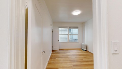 A long hallway with a window and a radiator.