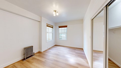 A room with wooden floors and a radiator on the wall.